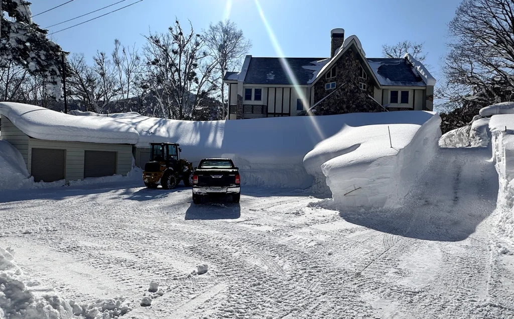 A Truck Parked In The Snow Beside A House
